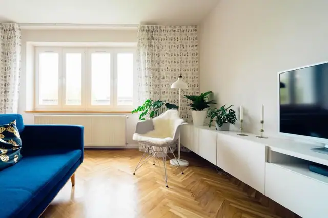 Bright living room with herringbone floor and tall windows